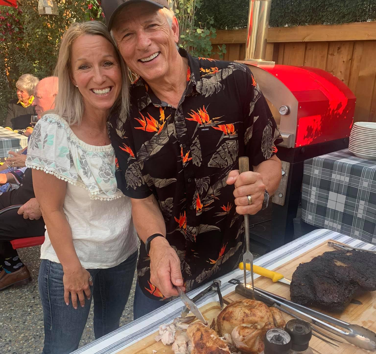 The family is enjoying a backyard barbecue at Excella Equine Estates, featuring country acreage living in Parkland County, Alberta.